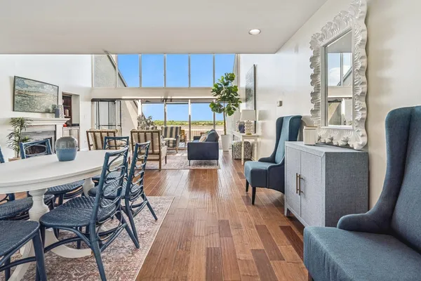 a living room with furniture a wooden floor and a large window