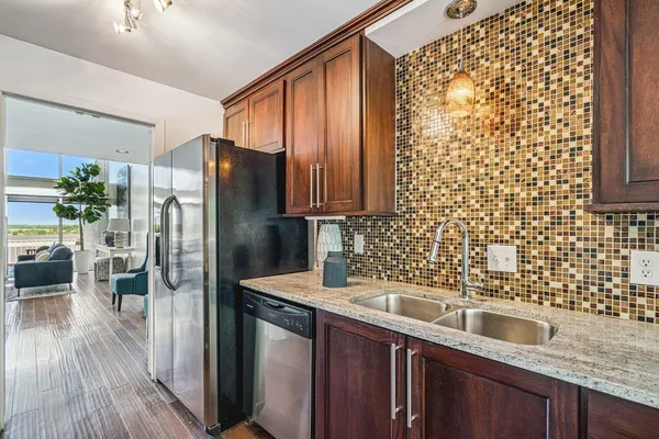 a kitchen with granite countertop a refrigerator and a sink