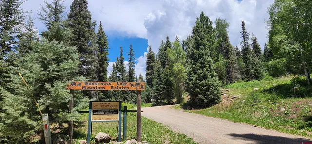 a sign board with buildings in the background