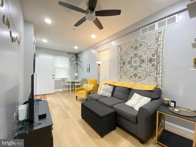 a living room with furniture and a ceiling fan