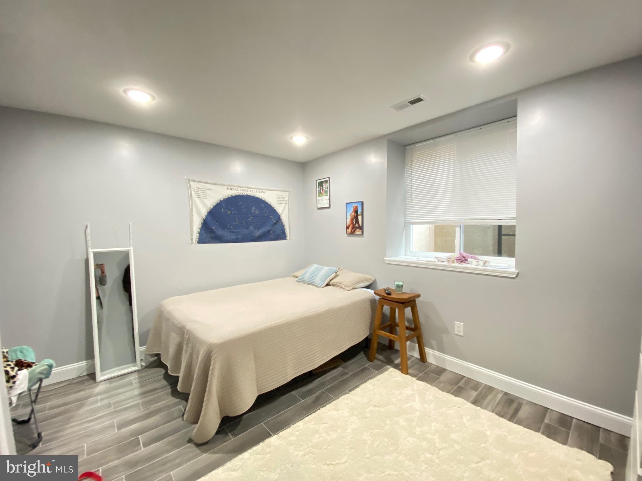 1932 North 8th Street, Unit 1 Philadelphia, PA 19122 - Photo 9 of 12 a bedroom with a bed and a night stand