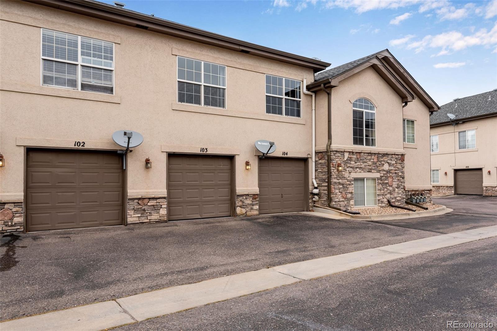 1405 South Chambers Road, Unit 103 Aurora, CO 80017 - Photo 4 of 20 a front view of a house with garage