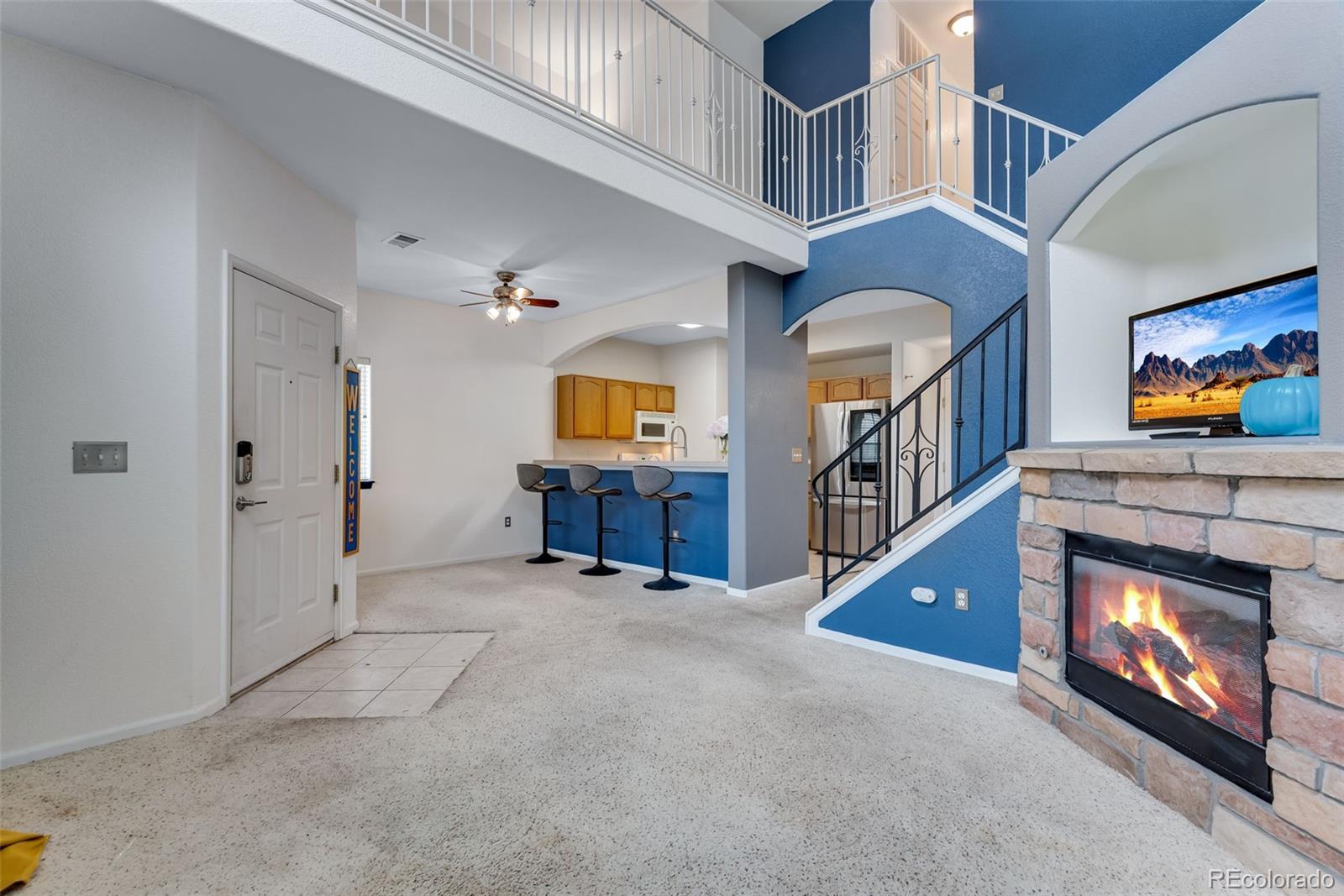 1405 South Chambers Road, Unit 103 Aurora, CO 80017 - Photo 6 of 20 a view of an empty room with stairs and a fireplace