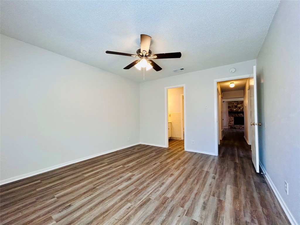 12005 Charing Cross Road, Unit A Austin, TX 78759 - Photo 12 of 19 a view of empty room with wooden floor and fan