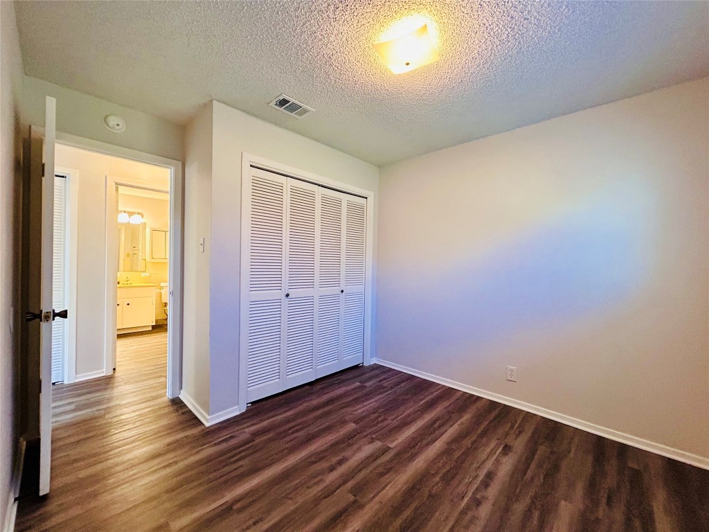 12005 Charing Cross Road, Unit A Austin, TX 78759 - Photo 16 of 19 a view of an empty room with wooden floor and closet