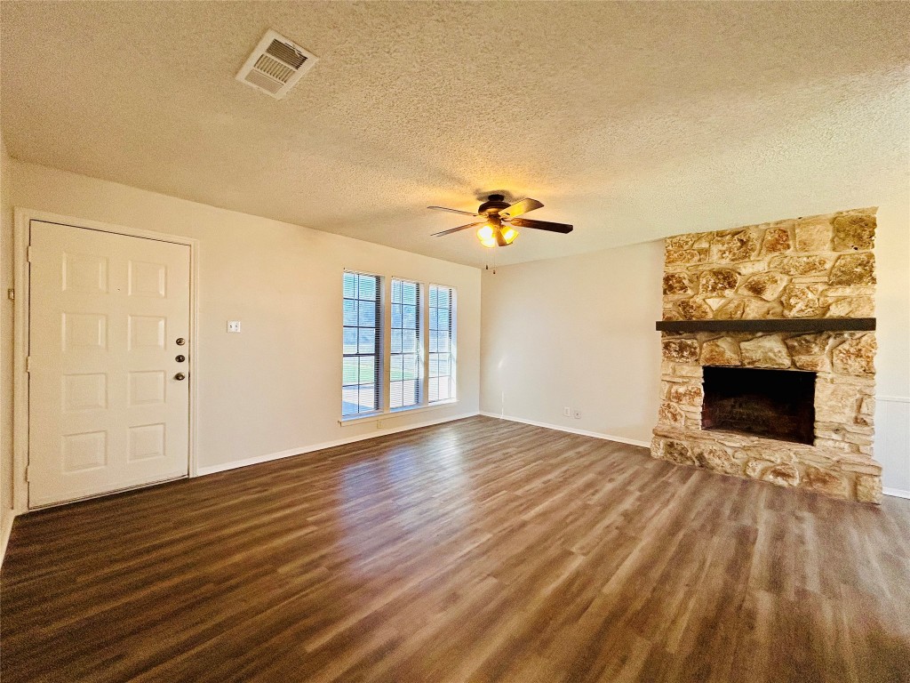 12005 Charing Cross Road, Unit A Austin, TX 78759 - Photo 2 of 19 a view of an empty room with wooden floor fireplace and a window