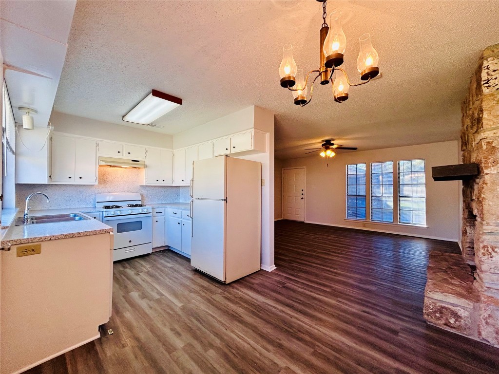 12005 Charing Cross Road, Unit A Austin, TX 78759 - Photo 5 of 19 a kitchen with stainless steel appliances wooden floors stove and white cabinets