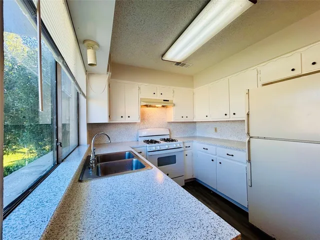 a kitchen with a stove a refrigerator and a sink