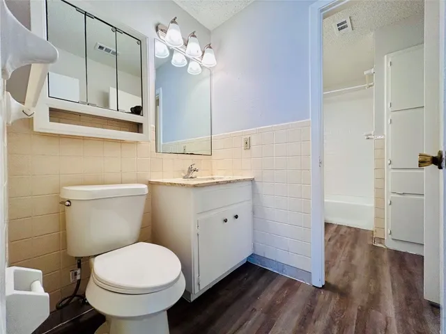 a bathroom with a sink a toilet a mirror and shower