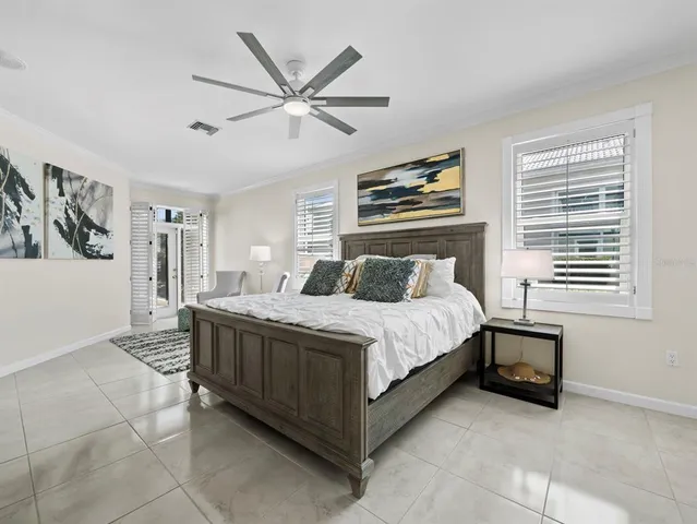 a bedroom with a bed a chair and large window