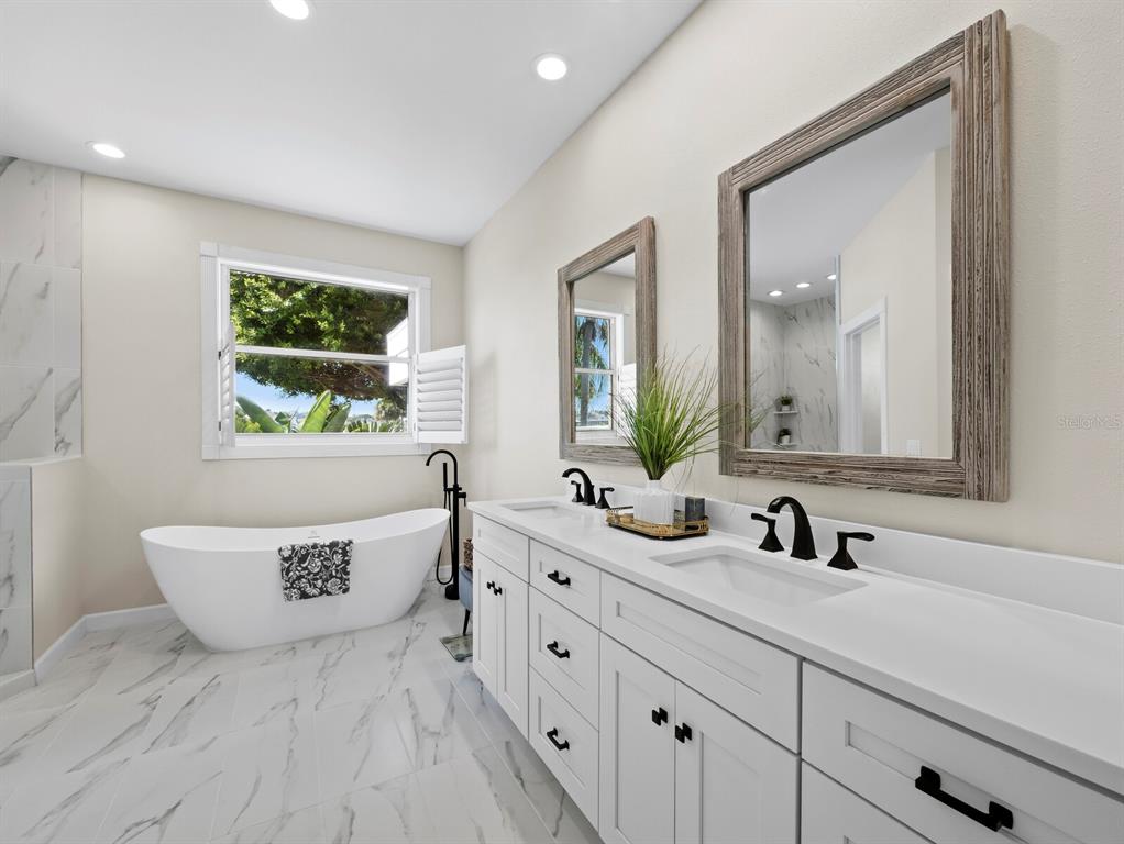 3408 Fair Oaks Lane Longboat Key, FL 34228 - Photo 30 of 76 a bathroom with a double vanity sink a mirror and a bathtub