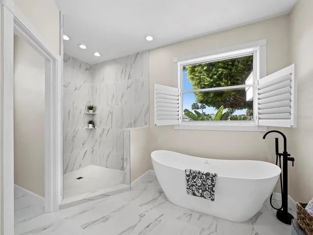 a spacious bedroom with a bed and a large window