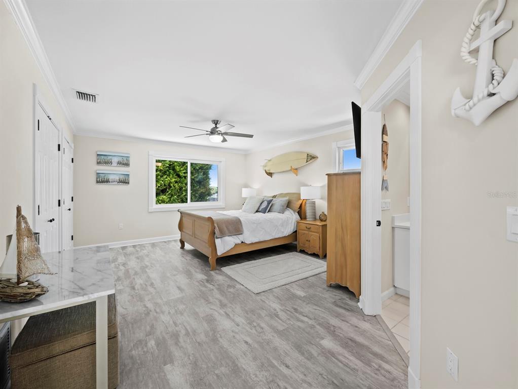 3408 Fair Oaks Lane Longboat Key, FL 34228 - Photo 38 of 76 a spacious bedroom with a bed and wooden floor