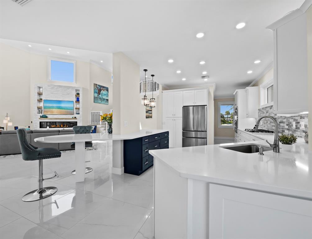 3408 Fair Oaks Lane Longboat Key, FL 34228 - Photo 8 of 76 a kitchen with stainless steel appliances kitchen island granite countertop a sink and a refrigerator