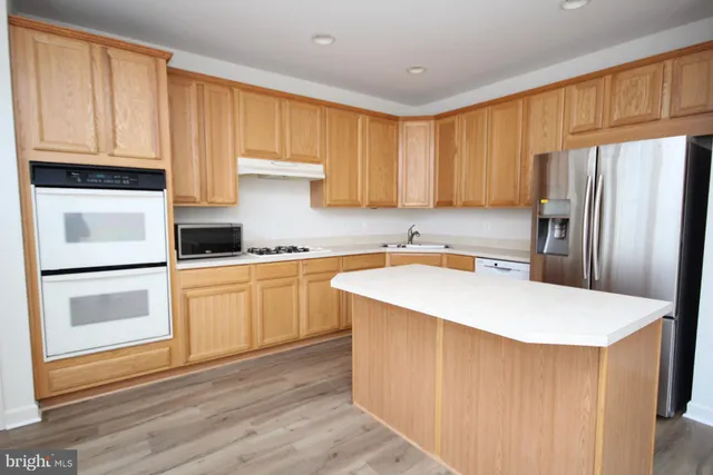 a view of a bedroom with wooden floor and furniture