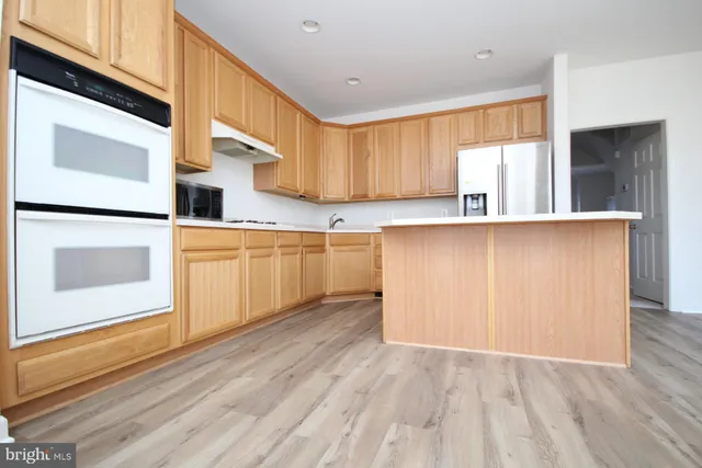 a view of a kitchen with a refrigerator a stove top oven and refrigerator