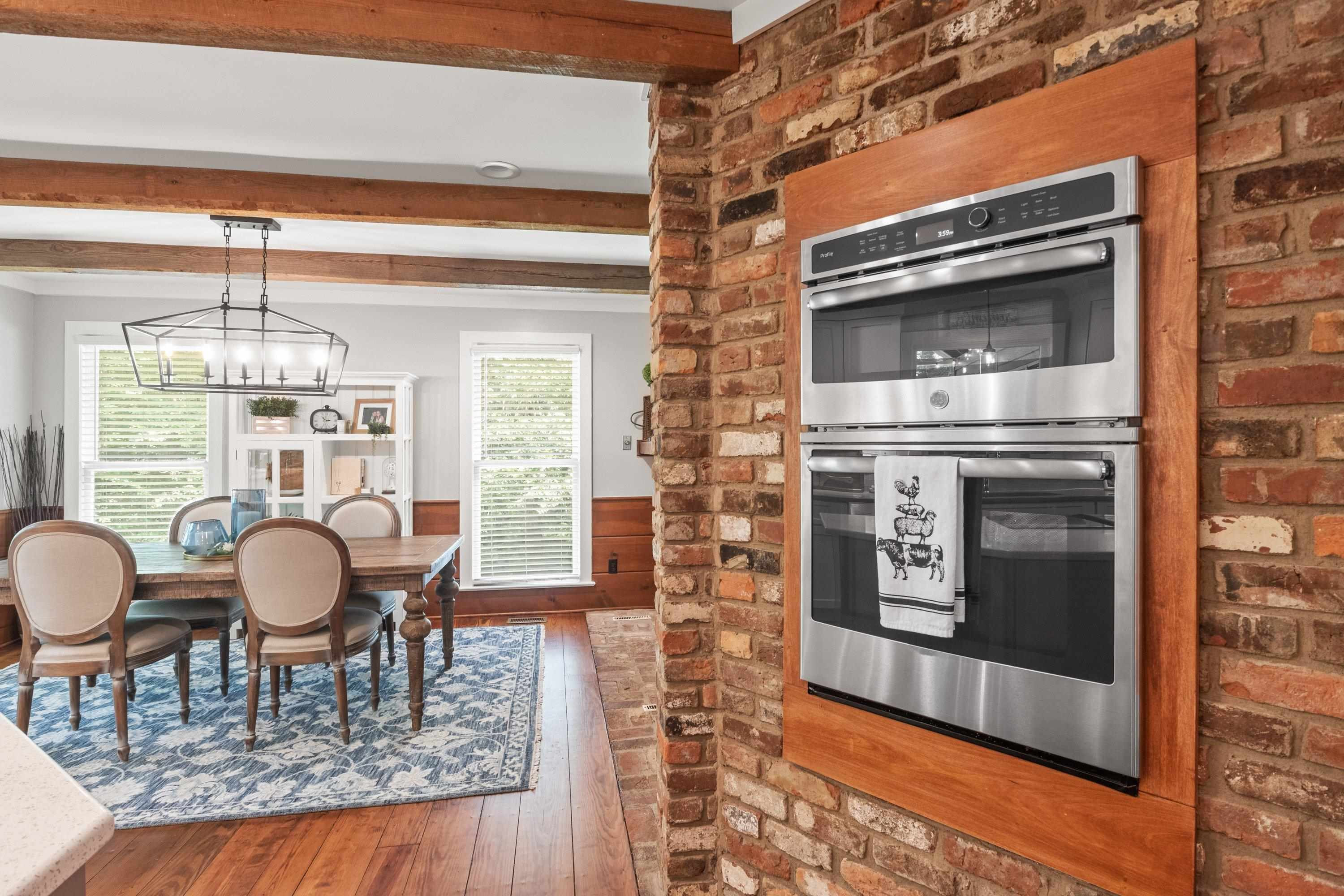 2420 Windsor Trail Raleigh, NC 27615 - Photo 18 of 72 a dining room with wooden floor a chandelier a glass table and chairs