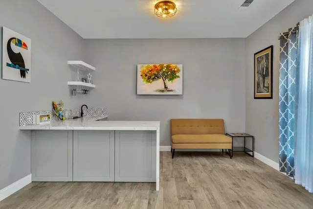 a kitchen with stainless steel appliances a table chairs refrigerator and cabinets