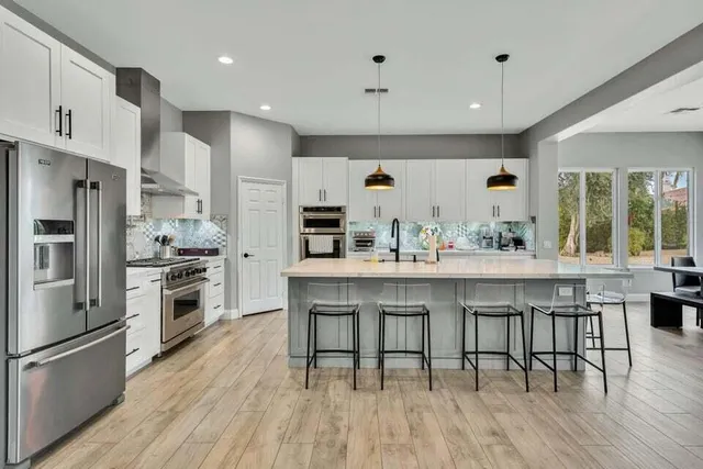 a kitchen with stainless steel appliances kitchen island granite countertop a sink stove and cabinets
