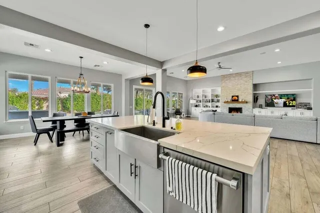 a dining room with wooden floor a chandelier a wooden table and chairs
