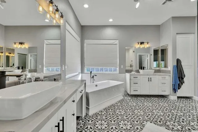 a bathroom with a double vanity sink a mirror and a bathtub