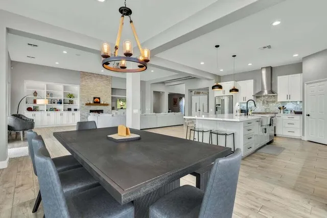 a view of a dining room and livingroom with furniture wooden floor a chandelier