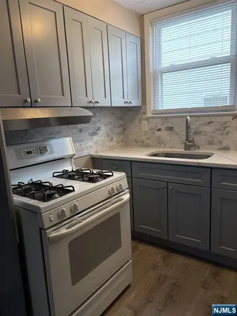 a kitchen with granite countertop cabinets stainless steel appliances and a sink
