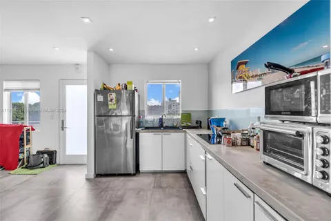 a kitchen with refrigerator and cabinets
