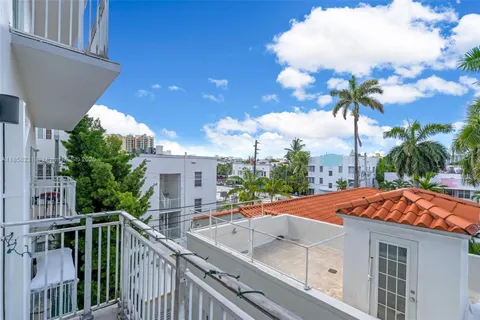 a view of a balcony with a floor to ceiling window and potted plants