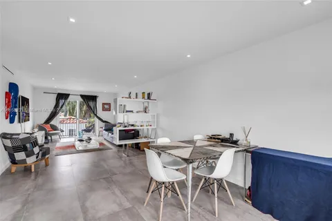 a living room with furniture and a dining table with wooden floor