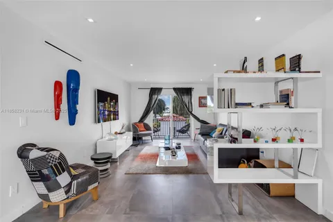 a living room with furniture gym equipment and view of kitchen appliances