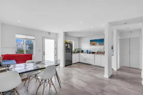 a kitchen with stainless steel appliances kitchen island granite countertop a refrigerator and cabinets