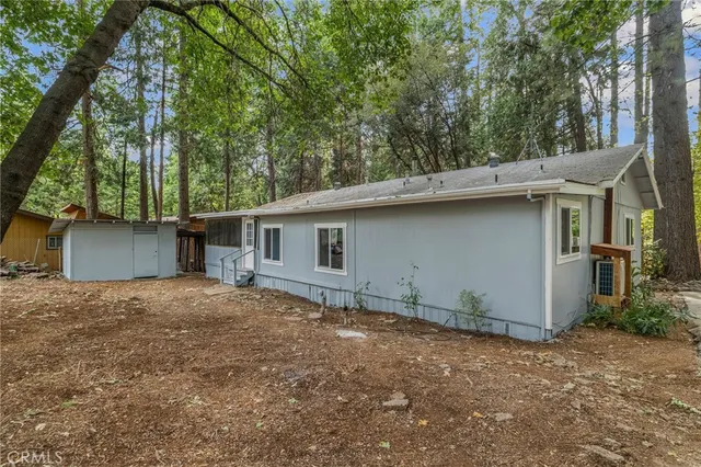 an aerial view of residential houses with outdoor space and trees