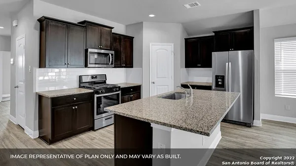 a kitchen with stainless steel appliances granite countertop a stove a refrigerator and a sink