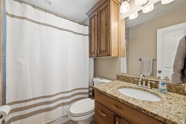 310 East 600 South Centerville, UT 84014 - Photo 16 of 41 Bathroom featuring a vanity with a granite countertop, undermount sink, and brushed nickel faucet