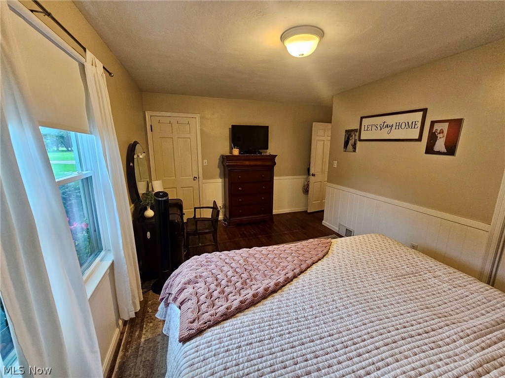 6620 West Lake Road Vermilion, OH 44089 - Photo 29 of 34 Wood-finish flooring, white paneled wainscoting, and a ceiling-mounted light fixture