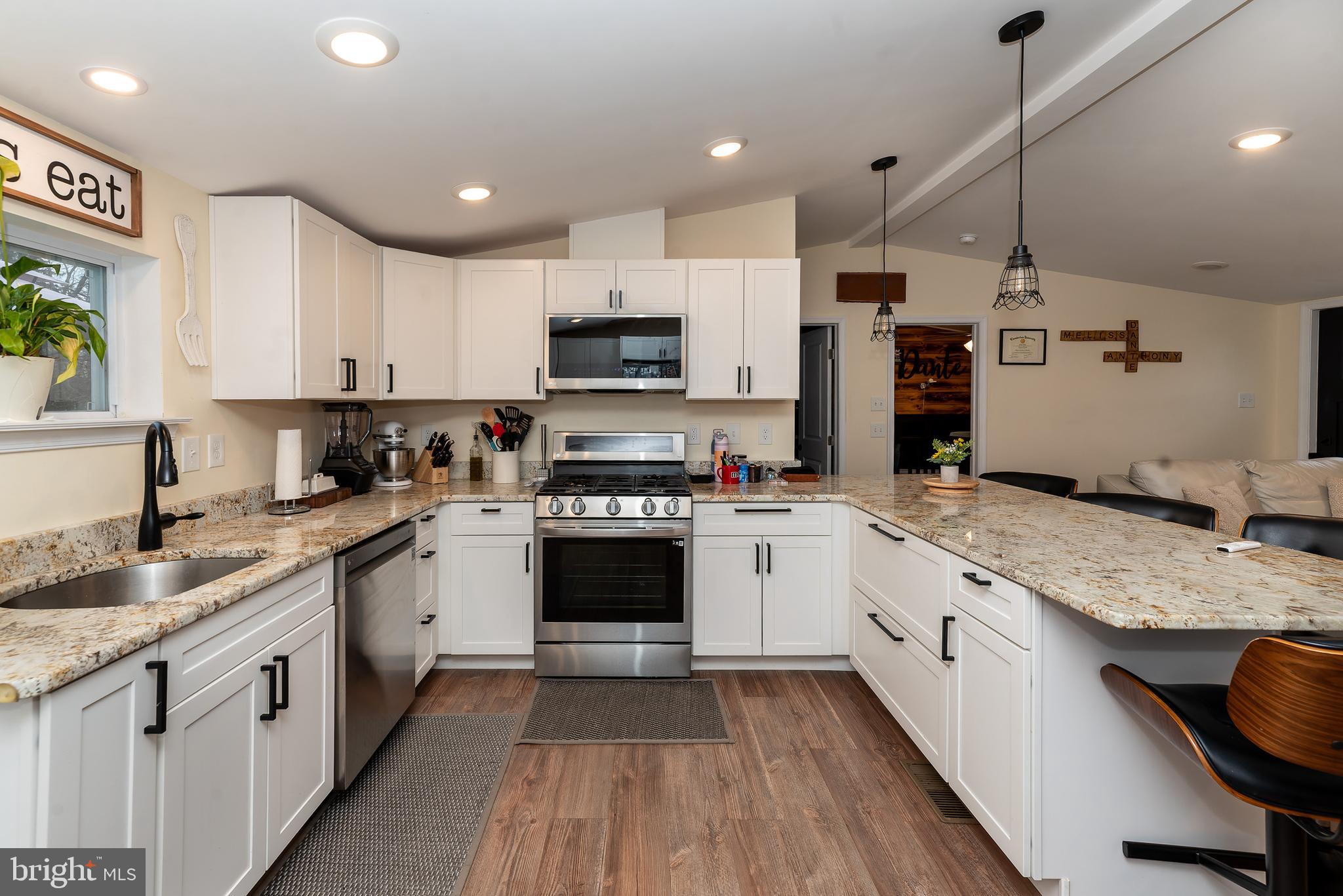 997 Williamstown Road Franklinville, NJ 08322 - Photo 11 of 62 a kitchen with stainless steel appliances granite countertop a stove top oven a sink dishwasher a refrigerator and white cabinets with wooden floor