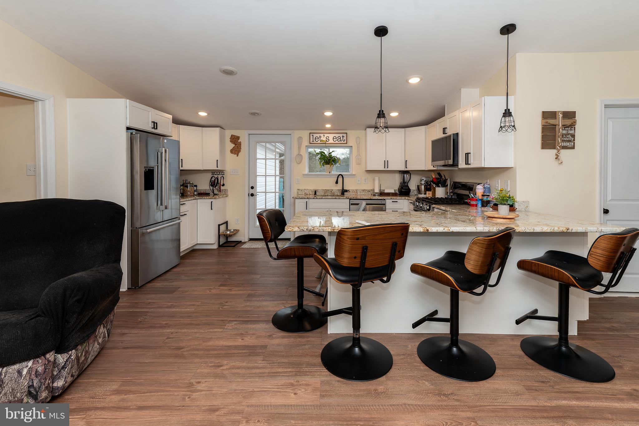 997 Williamstown Road Franklinville, NJ 08322 - Photo 9 of 62 a kitchen with stainless steel appliances kitchen island granite countertop a table chairs and a refrigerator