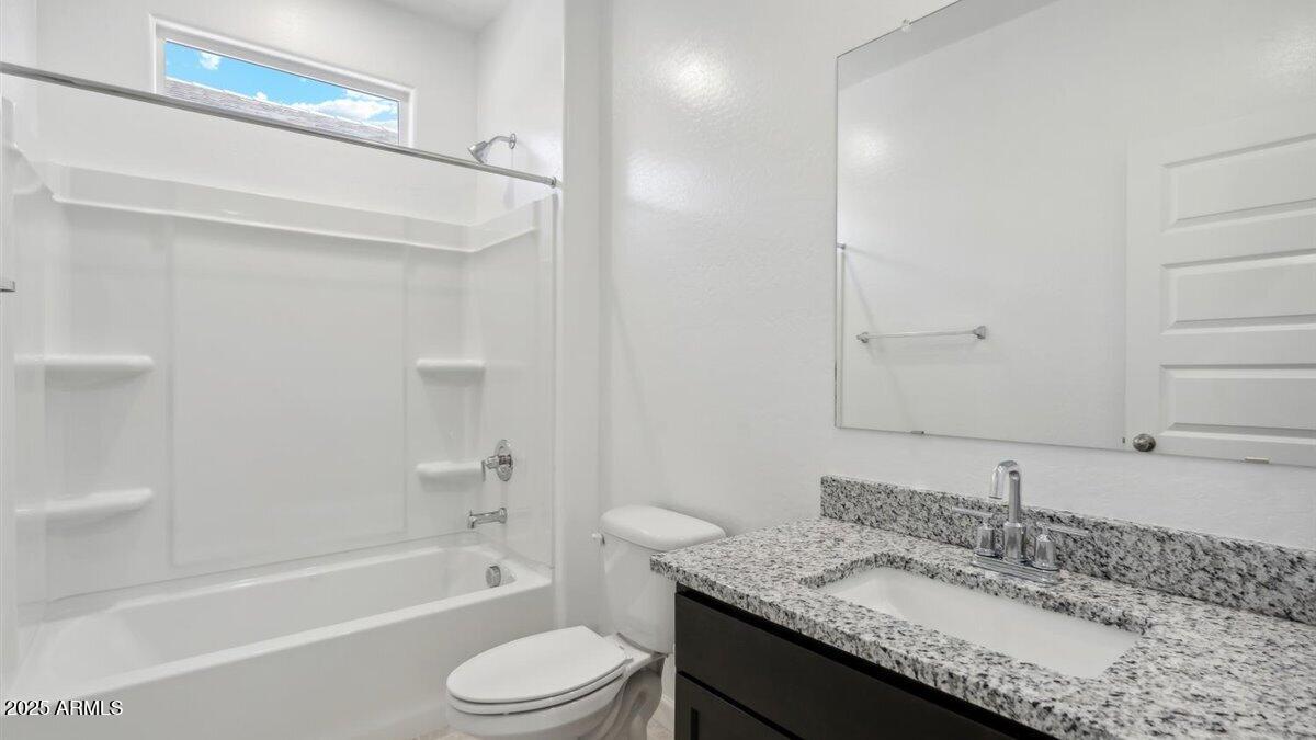 2127 Starkey Avenue Apache Junction, AZ 85120 - Photo 14 of 17 a bathroom with a granite countertop sink a toilet and bathtub