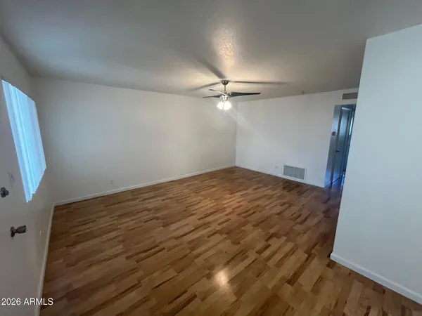 a view of empty room with wooden floor