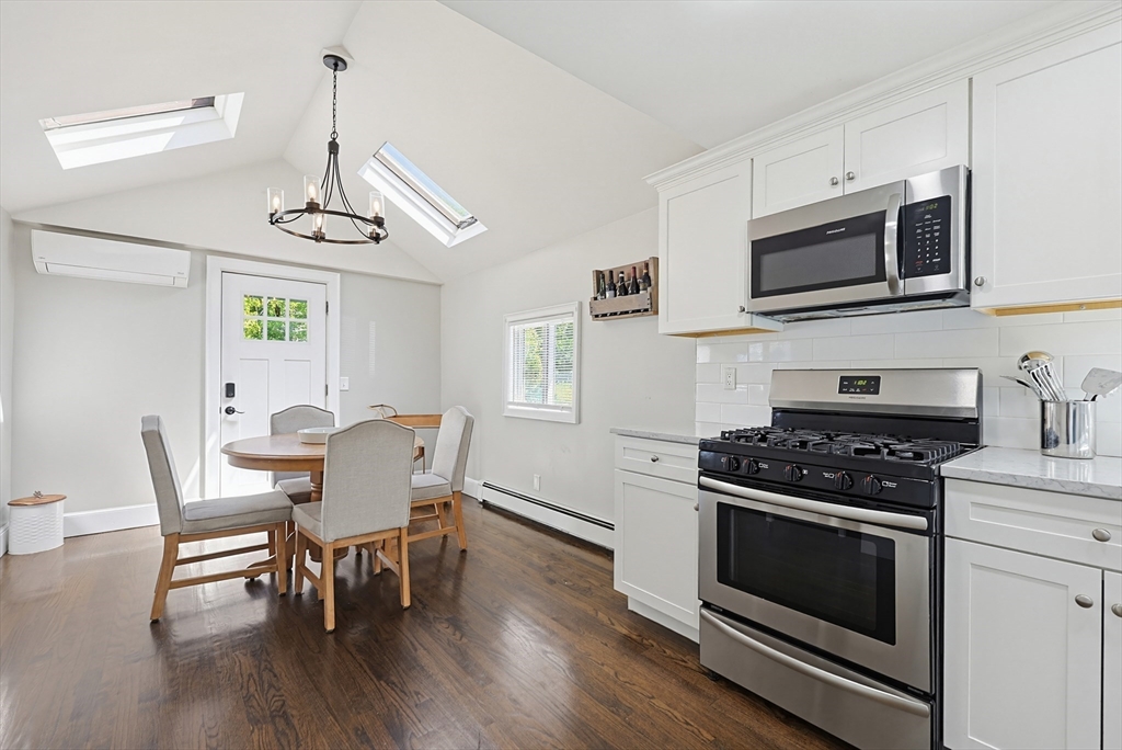 345 Sherman Street Canton, MA 02021 - Photo 7 of 42 a kitchen with stainless steel appliances a stove a microwave a sink a dining table and chairs