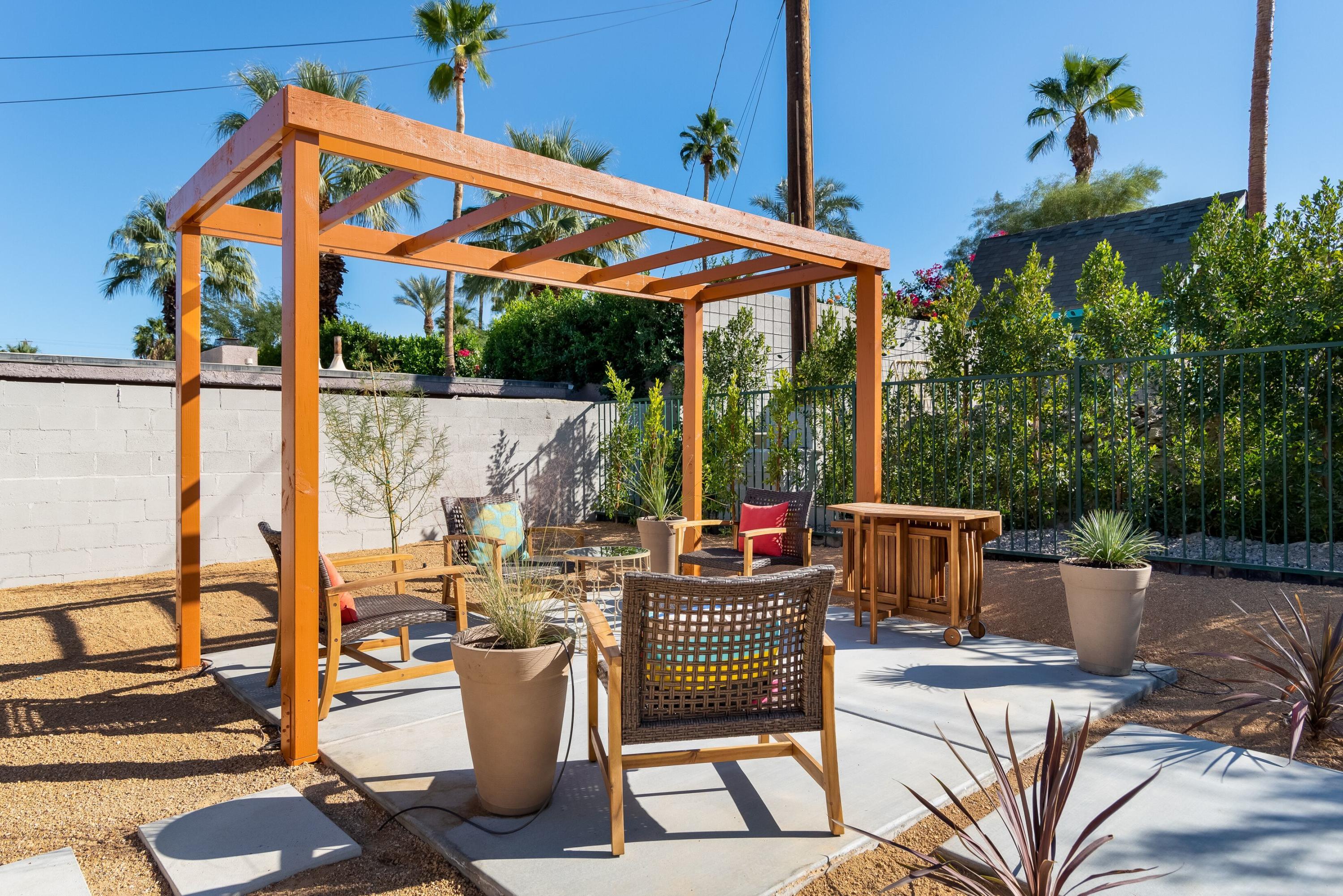 68195 Terrace Road Cathedral City, CA 92234 - Photo 27 of 33 a view of a patio with table and chairs potted plants with wooden floor and fence