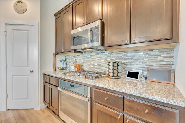 a kitchen with stainless steel appliances granite countertop a sink and a microwave