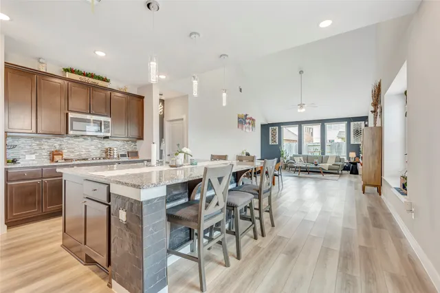 a large kitchen with cabinets table and chairs