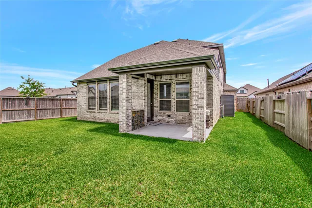 a view of a house with a yard potted plants and wooden fence