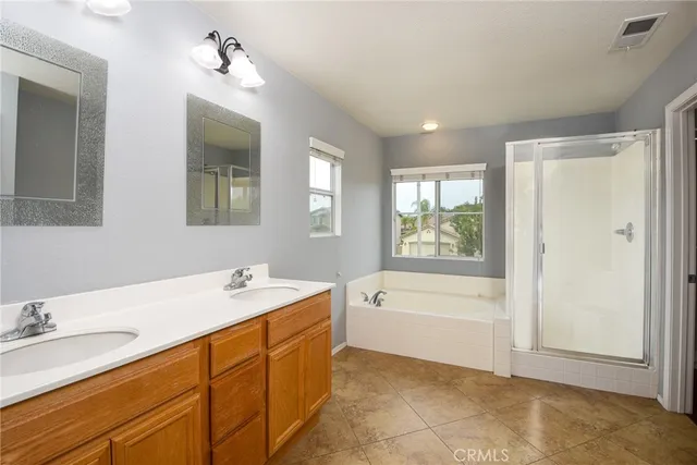 a spacious bathroom with a tub sink and mirror