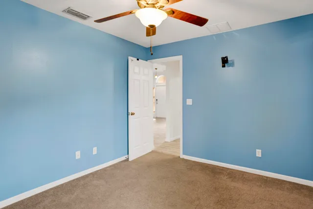 an empty room with closet and a chandelier fan