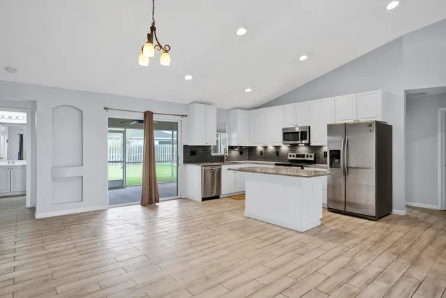 a kitchen with stainless steel appliances a refrigerator sink and cabinets