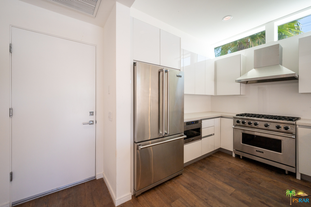 1521 South Belardo Road Palm Springs, CA 92264 - Photo 22 of 37 a kitchen with a refrigerator stove and wooden floor
