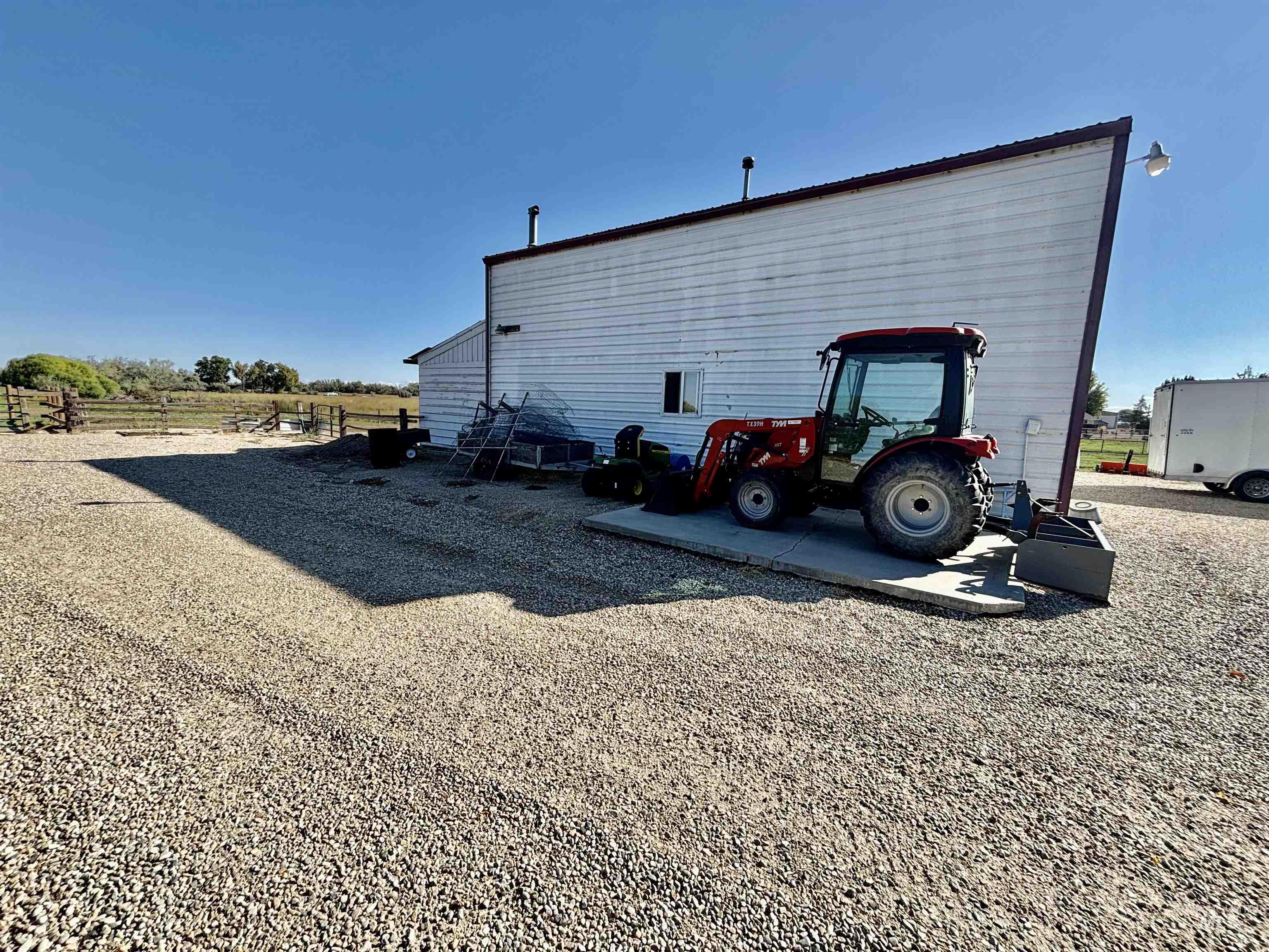 23626 Boise River Road Caldwell, ID 83607 - Photo 34 of 49 White siding exterior with a sloped roofline, gravel lot, and concrete pad